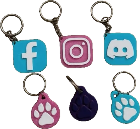 Llaveros impresos en 3D con chip NFC: tres con huella de mascota y tres con íconos de redes sociales